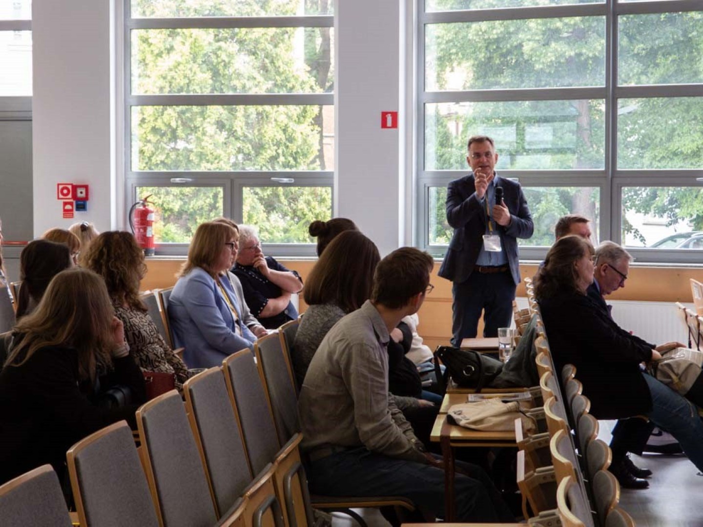 grupa słuchająca mówiącego mężczyzny